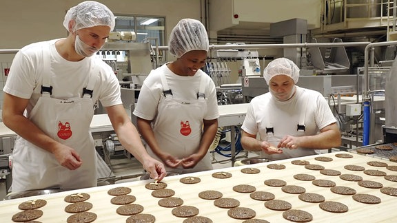 Drei Personen stellen Lebkuchen her