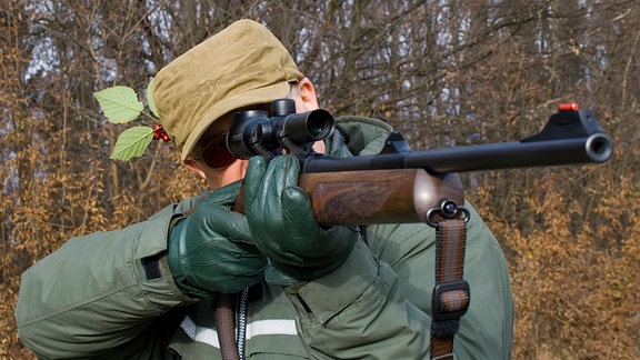 Ein Mann zielt mit einem Gewehr.