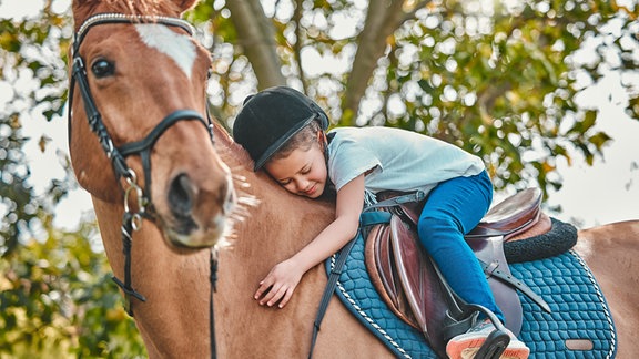 Kind sitzt auf einem Pferd