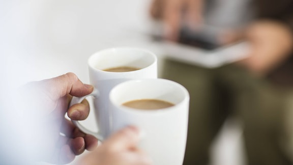 Eine Frau hält zwei Kaffeebecher