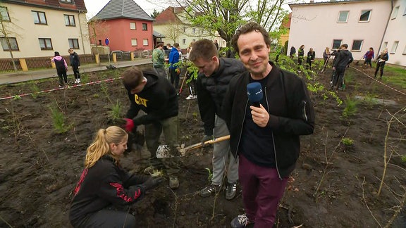 Der Reporter bei Schülern in einem Beet