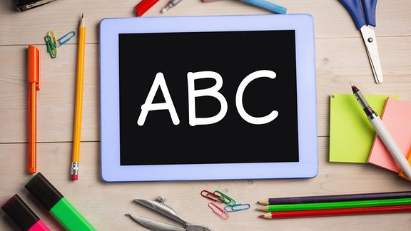 Tablet mit den Buchstaben ABC. Drum herum liegen Stifte.