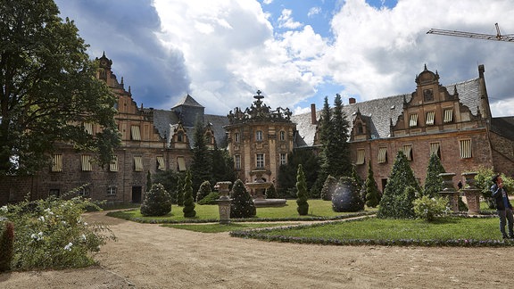 Schloss Vitzenburg, umgeben von einem Park, im Hintergrund blauer Himmel