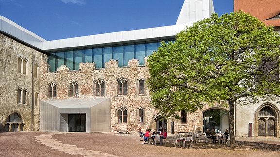 Außenansicht Kunstmuseum Moritzburg in Halle: ein mittelalterlicher Bau mit modernem Glasdach vor blauem Himmel