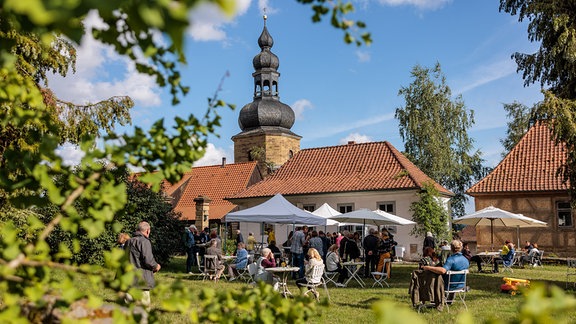 Kirche St. Kilian und Schlosshof mit Sonnenschirmen in Bedheim