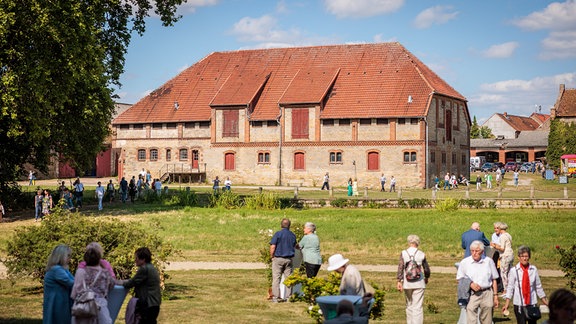 Außenansicht Konzertstall in Seggerde mit blauem Himmel und Sonnenschein mit Konzertgästen im Vordergrund