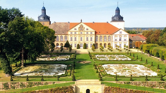 Ein Schloss, umgeben von einem symmetrisch angelegten Garten.