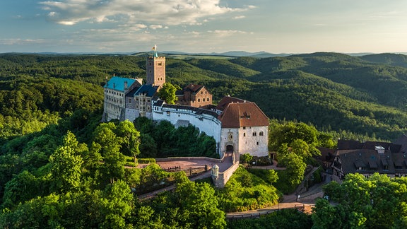 Luftbild der Wartburg inmitten von grünen Hügeln