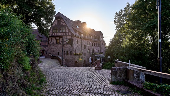 Aufgang zur Wartburg, Blick auf Hotel, hinter dessen Dach die Sonne untergeht