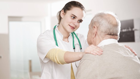 Symbolfoto: junge Frau kümmert sich um älteren Mann