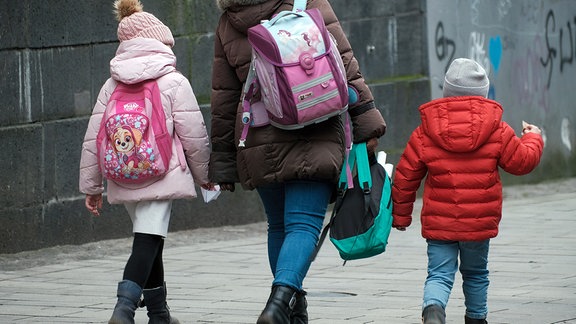 Mutter mit Kinder auf dem Schulweg