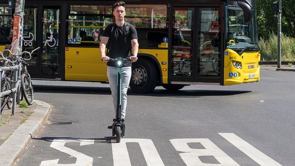 ILLUSTRATION - Ein Mann faehrt am 10.07.2019 mit einem gemieteten E-Tretroller in Berlin auf einer Busspur (gestellte Szene). Foto: Robert Guenther