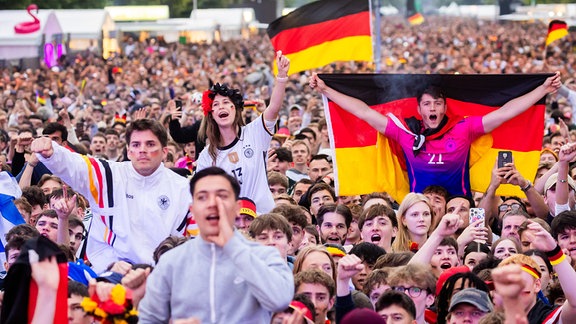 Eine bunte Menschenmasse: Deutschland-Fans feiern mit Deuitschlandfahnen und anderen schwarz-rot-goldenen Fanartikeln beim Public Viewing das Eröffnungsspiel der Fußball-EM.