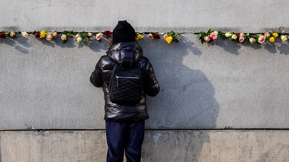 Blumen stecken nach einer zentralen Gedenkveranstaltung anlässlich von 35 Jahre friedliche Revolution und Mauerfall in der Gedenkstätte Berliner Mauer in der Hinterlandmauer. 