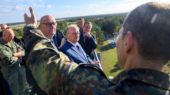 Dietmar Woidke (2.v.l.), Ministerpräsident von Brandenburg, Reiner Haseloff (M, CDU), Ministerpräsident von Sachsen-Anhalt und Bundesverteidigungsminister Boris Pistorius (2.v.r, SPD) stehen auf dem Tower vom Fliegerhorst Holzdorf und verschaffen sich einen Überblick über den Standort. 