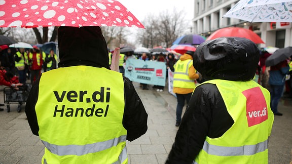 Teilnehmer einer Verdi-Kundgebung tragen gelbe Westen mit der ver.di Aufschrift