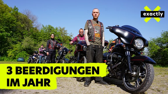 Ein Mann steht vor einem Motorrad.