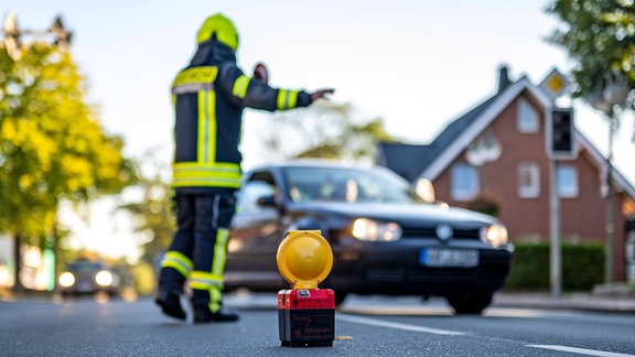 Ein Feuerwehrmann leitet den Verkehr um