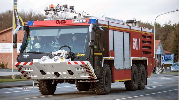  Ein Fahrzeug der Bundeswehrfeuerwehr fährt am 28.03.2016 zu einem Brand auf dem Gelände des Geflügelproduzenten Wiesenhof in Lohne (Niedersachsen). Foto: Lars Klemmer/dpa (Zu dpa "Großbrand bei Geflügelproduzent Wiesenhof" vom 28.03.2016)