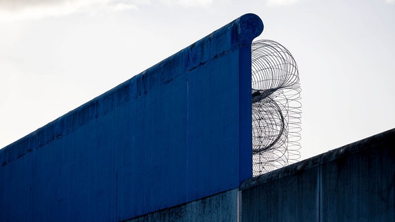 Blick auf Mauern und Stacheldraht an der Justizvollzugsanstalt Dresden - Hammerweg.