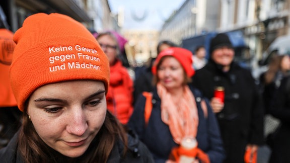 Eine Frau trägt bei einer Mahnwache eine Mütze mit der Aufschrift "Keine Gewalt gegen Frauen und Mädchen".