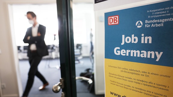 Ein Mann geht in einem Jobberatungszentrum an einem Plakat mit der Aufschrift «Job in Germany» vorbei