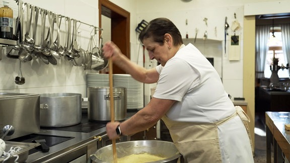 Eine Frau rührt Kloßteig.