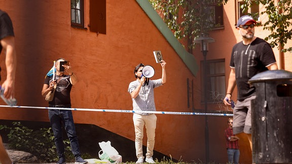 Ein Mann hält den Koran in der Hand.