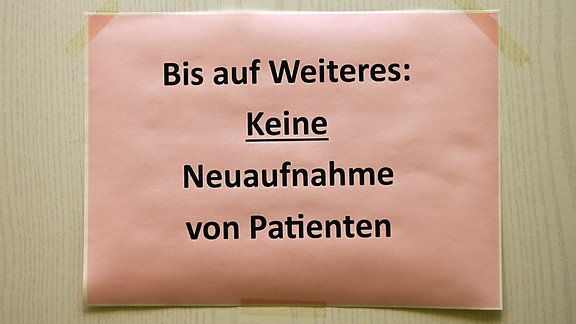 Zettel mit dem Hinweis Bis auf Weiteres: Keine Neuaufnahme von Patienten an der Tür einer Hausarztpraxis