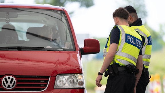 Bundespolizisten stehen bei Grenzkontrollen auf dem Rastplatz „Am Heideholz“ an der Autobahn 17 nahe der deutsch-tschechischen Grenze an einem Kleinbus.