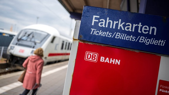 Touristen laufen mit Rollkoffern am Bahnhof Norddeich-Mole entlang.