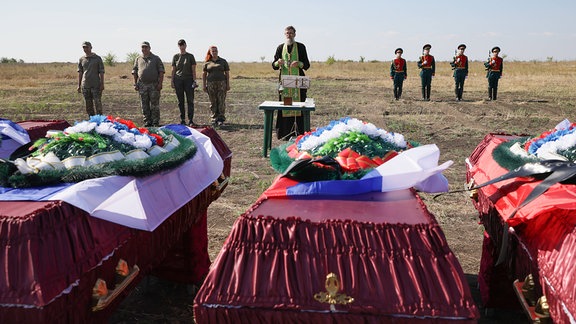 Ein Priester nimmt an einem Begräbnis von Überresten getöteter russischer Soldaten teil.