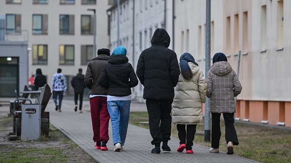 Migranten gehen über das Gelände der Zentralen Erstaufnahmeeinrichtung für Asylbewerber des Landes Brandenburg in Eisenhüttenstadt.