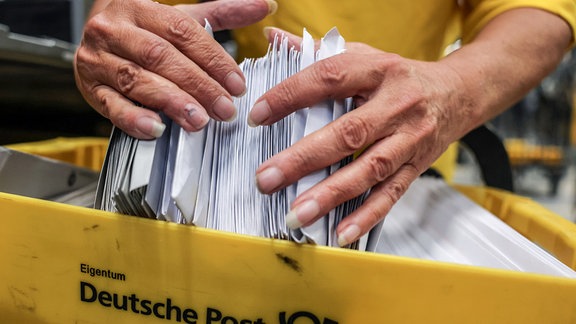 Eine Mitarbeiterin der Deutschen Post DHL sortiert Briefe im Briefverteilzentrum.