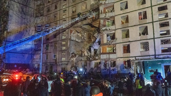 Rettungskräfte helfen Menschen, nachdem ein mehrstöckiges Wohnhaus am Mittwoch von einem russischen Angriff getroffen wurde.