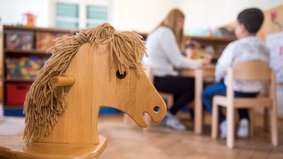 Kinder spielen im Frauenhaus und werden von Mitarbeitern betreut.