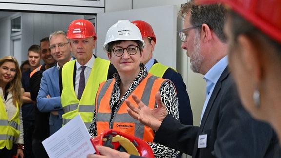 Klara Geywitz (M, SPD), Bundesbauministerin, unterhält sich auf ihrer Sommerreise mit Andreas Göbel (r), Architekt Daiwa House, beim japanischen Modulbaukonzern Daiwa House Group.