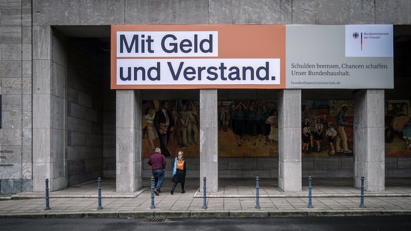 Ein Plakat mit der Aufschrift «Mit Geld und Verstand. Schulden bremsen, Chancen schaffen. Unser Bundeshaushalt.» hängt über dem Eingang zum Bundesministerium der Finanzen. 