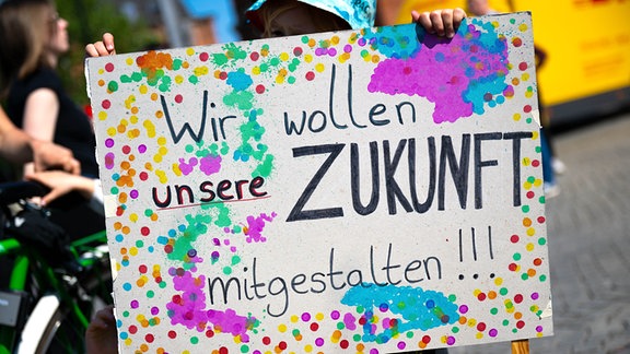 Ein Kind hält bei einer Demonstration des Bündnisses «Bildungswende jetzt!» während der Jugend- und Familienministerkonferenz (JFMK) ein Plakat mit der Aufschrift «Wir wollen unsere Zukunft mitgestalten!».