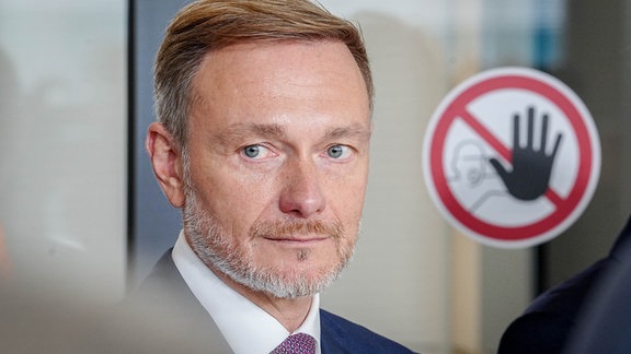 Christian Lindner (FDP), Bundesminister der Finanzen und FDP-Parteivorsitzender, steht nach dem Treffen seiner Fraktion mit Wirtschaftsverbänden im Reichstagsgebäude auf der Fraktionsebene des Bundestags neben einem Halte-Hinweisschild.