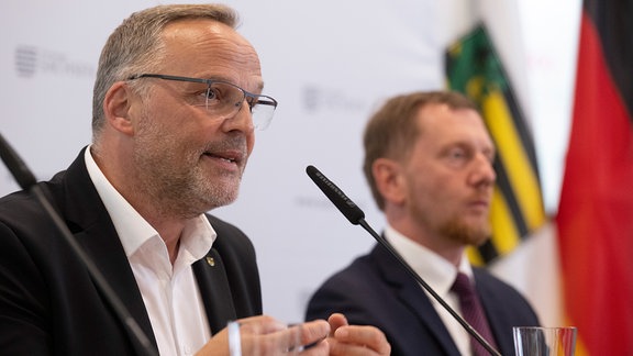 Dirk Neubauer und Michael Kretschmer sprechen 2023 auf einer Pressekonferenz.