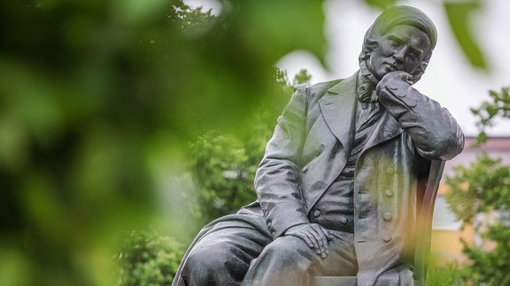 Das Denkmal des Komponisten Robert Schumann steht vor dem Gewandhaus Zwickau.