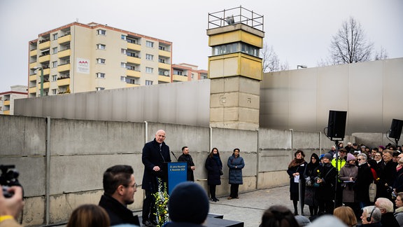 Kai Wegner (CDU), Regierender Bürgermeister von Berlin, spricht bei einer zentralen Gedenkveranstaltung anlässlich von 35 Jahre friedliche Revolution und Mauerfall in der Gedenkstätte Berliner Mauer an der Hinterlandmauer.