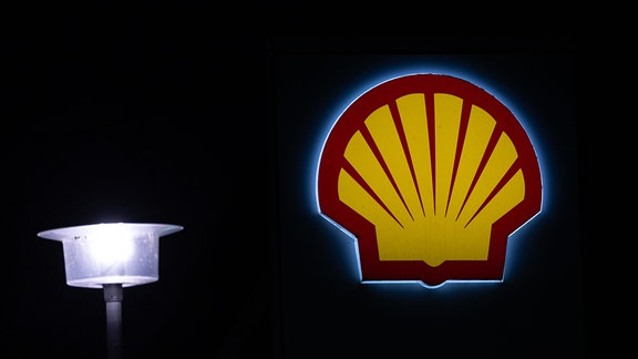 Ein Shell-Logo einer Tankstelle leuchtet im Dunkeln in Berlin.