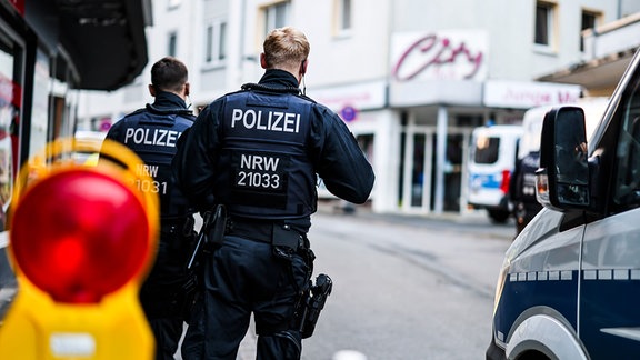 Polizisten stehen am frühen Morgen an einer Absperrung in der Innenstadt.