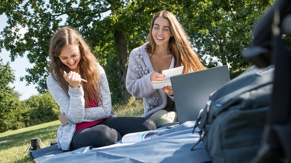 Studentinnen auf einer Wiese