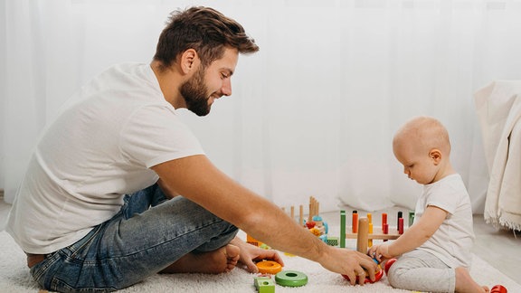 Vater und Kind spielen zusammen.