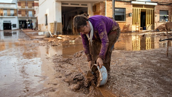 Eine Frau hilft bei den Aufräumarbeiten nach dem verheerenden Unwetter. 