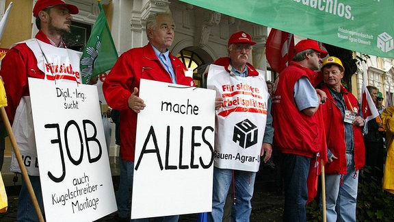 Gewerkschafter protestieren vor dem landtag in Magdeburg, Sachsen-Anhalt, am Donnerstag, 18. Juli 2002. Die neue Regierung will das so genannte Vergabegesetz wieder abschaffen. Nach dem gesetz duerfen oeffentliche Auftraege nur an Unternehmen vergeben werden, die Tarifloehne zahlen.