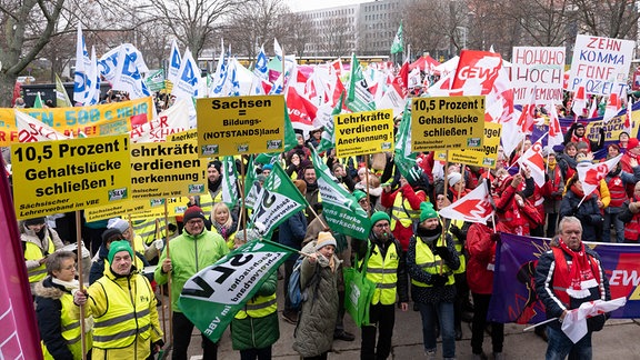 Teilnehmer einer Kundgebung der Bildungsgewerkschaft GEW stehen auf dem Carolaplatz. 